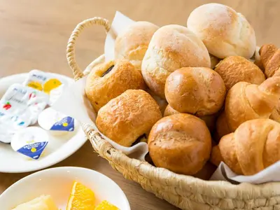 a basket filled with bread rolls on a table at Hotel Route-Inn Tokyo Ikebukuro in Tokyo