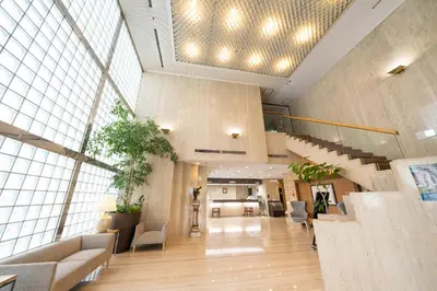 a large lobby with a staircase in a building at Hotel Sunlite Shinjuku in Tokyo