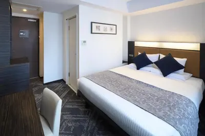 a hotel room with a large bed and a desk at HOTEL MYSTAYS Hamamatsucho in Tokyo
