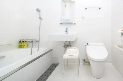 a white bathroom with a toilet and a sink at HOTEL MYSTAYS Hamamatsucho in Tokyo