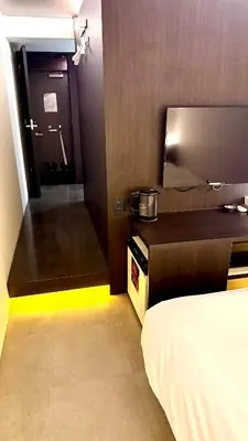 a room with a bed and a kitchen with a door at Hills Hotel Gotanda in Tokyo