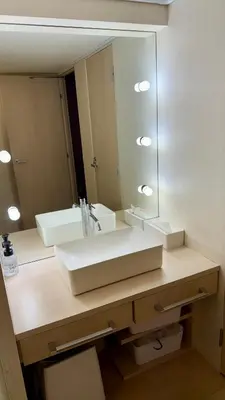a bathroom with a sink and a large mirror at Hills Hotel Gotanda in Tokyo
