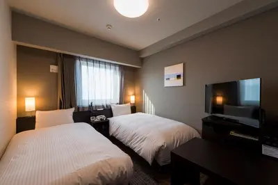 a hotel room with two beds and a flat screen tv at Hotel Route-Inn Grand Tokyo Asakusabashi in Tokyo