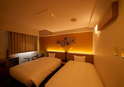 two beds in a hotel room with lights at Smile Hotel Tokyo Asagaya in Tokyo