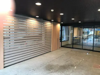 a building with a metal garage door with windows at Smile Hotel Tokyo Asagaya in Tokyo