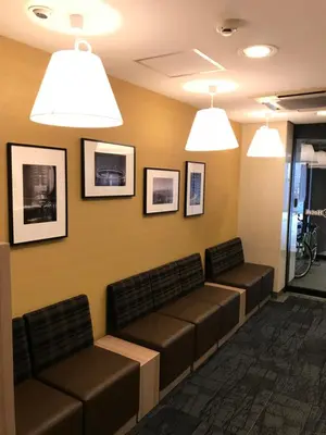 a waiting room with benches and pictures on the wall at Smile Hotel Tokyo Asagaya in Tokyo