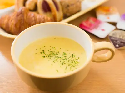 a bowl of soup with bread and a plate of food at Super Hotel Tokyo Nihombashi Mitsukoshimae in Tokyo