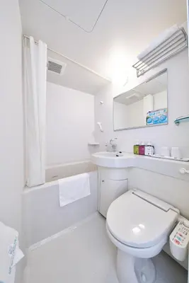 a white bathroom with a toilet and a sink at Super Hotel Tokyo Nihombashi Mitsukoshimae in Tokyo