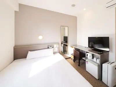 a bedroom with a large white bed and a television at Super Hotel Tokyo Nihombashi Mitsukoshimae in Tokyo