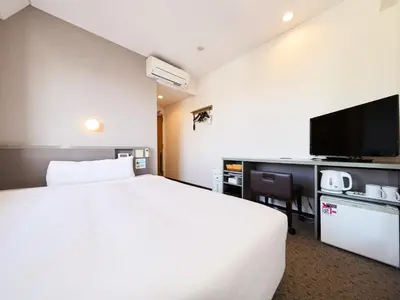 a hotel room with a white bed and a tv at Super Hotel Tokyo Nihombashi Mitsukoshimae in Tokyo
