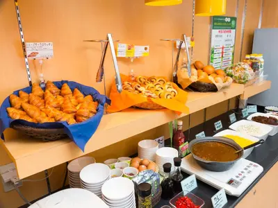 a buffet with bread and other foods on shelves at Super Hotel Tokyo Nihombashi Mitsukoshimae in Tokyo