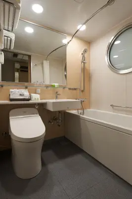 a bathroom with a toilet and a sink and a tub at HOTEL 1899 TOKYO in Tokyo