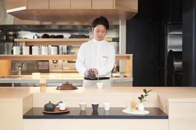 a chef standing in a kitchen preparing food at HOTEL 1899 TOKYO in Tokyo