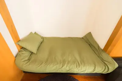 a green bed in a corner of a room at K&K Apartment Kita-Akabane #301 in Tokyo