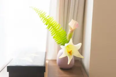 a vase with two flowers sitting on a window sill at K&K Apartment Kita-Akabane #301 in Tokyo