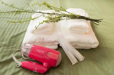 a pink hair dryer next to a pile of towels at K&K Apartment Kita-Akabane #301 in Tokyo