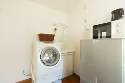 a washing machine in a kitchen next to a refrigerator at K&K Apartment Kita-Akabane #301 in Tokyo