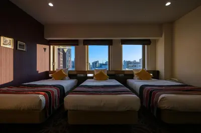 a room with three beds in a room with windows at HOTEL MYSTAYS Ueno East in Tokyo