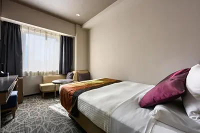 a hotel room with a bed and a desk and a window at HOTEL MYSTAYS Ueno East in Tokyo