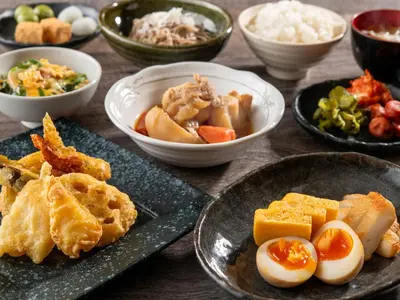 a table with plates of food and bowls of food at HOTEL MYSTAYS Ueno East in Tokyo