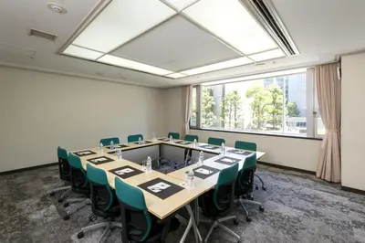 a conference room with a long table and green chairs at Chisun Hotel Hamamatsucho in Tokyo
