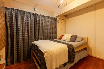 a bedroom with a bed and a window with curtains at Premier suite MEGURO Tokyo in Tokyo
