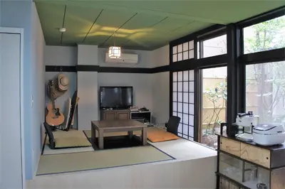 a living room with a table and a guitar at Juyoh Hotel in Tokyo