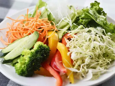 a plate of food with vegetables on a table at Hotel Resol Ikebukuro in Tokyo