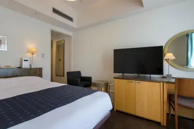 a hotel room with a bed and a flat screen tv at Hotel Monterey Ginza in Tokyo