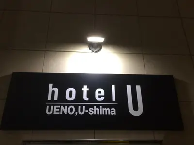 a sign for a hotel with a light on the ceiling at Hotel U in Tokyo