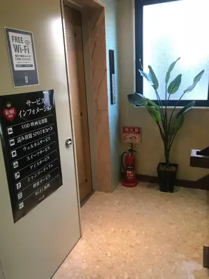 a sign on a door in a room with a plant at Hotel U in Tokyo