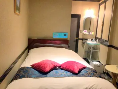 a bedroom with two red pillows on a bed at Hotel U in Tokyo