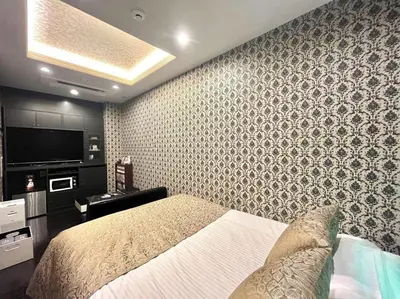 a bedroom with a bed and a wall at Hotel U in Tokyo