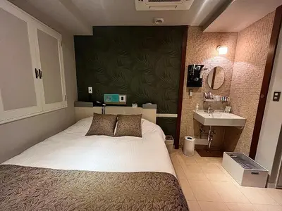a bedroom with a bed and a sink at Hotel U in Tokyo