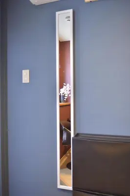 a mirror in a room next to a refrigerator at Mervielle Ueno in Tokyo