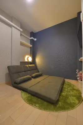 a bedroom with a large bed on a green rug at Mervielle Ueno in Tokyo