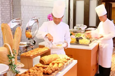 two chefs standing in a kitchen preparing food at Hotel Tokyo Garden Palace in Tokyo