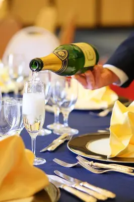 a person pouring champagne into a glass on a table at Hotel Tokyo Garden Palace in Tokyo