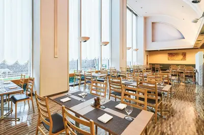 a restaurant with tables and chairs and large windows at Hotel Tokyo Garden Palace in Tokyo