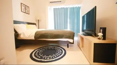 a bedroom with a bed and a flat screen tv at Uhome Kanda Hotel in Tokyo
