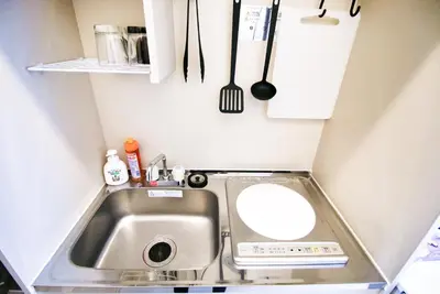 a small kitchen with a sink and utensils at Uhome Kanda Hotel in Tokyo