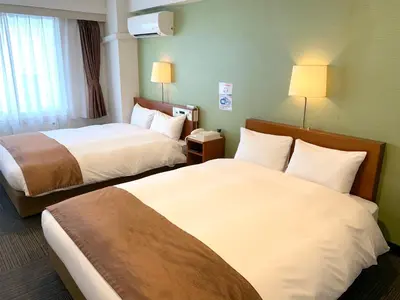 a hotel room with two beds and two lamps at Tokyo Plaza Hotel in Tokyo