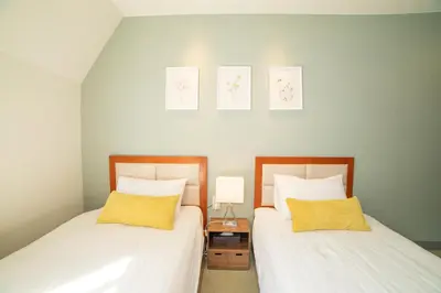 two beds sitting next to each other in a bedroom at Tabata Oji Hotel in Tokyo