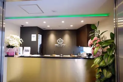 a lobby with a counter with flowers on it at Tabata Oji Hotel in Tokyo