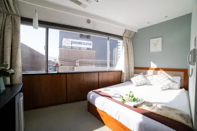 a bedroom with a bed and a large window at Tabata Oji Hotel in Tokyo