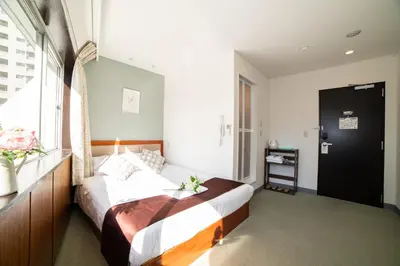 a bedroom with a bed and a window at Tabata Oji Hotel in Tokyo