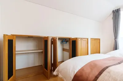 a bedroom with two beds and wooden cabinets at Luxury Guest House in Tokyo Shinjuku in Tokyo