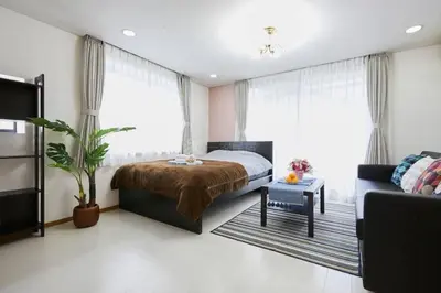 a bedroom with a bed and a couch at Luxury Guest House in Tokyo Shinjuku in Tokyo