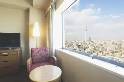 a room with a chair and a window with a view at Dai-ichi Hotel Ryogoku in Tokyo