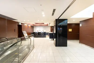 an empty lobby of a building with a glass elevator at Hotel Keihan Asakusa in Tokyo
